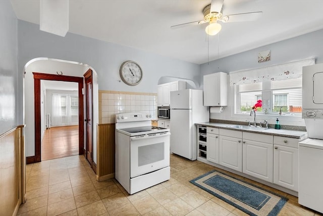 130 Francis St, Everett, MA 02149 - kitchen with white appliances, stacked washer / drying machine, a ceiling fan, and white cabinetry