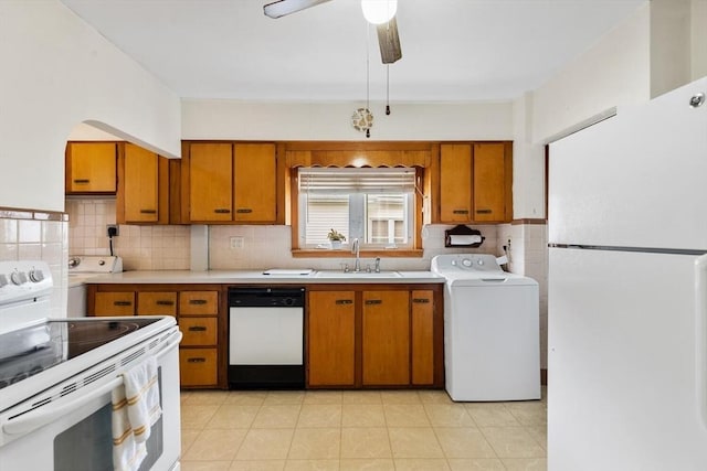 130 Francis St, Everett, MA 02149 - kitchen with white appliances, washer / clothes dryer, brown cabinetry, light countertops, and decorative backsplash