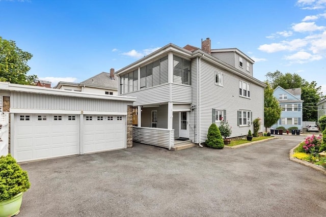 130 Francis St, Everett, MA 02149 - view of front facade with asphalt driveway, a chimney, and an attached garage