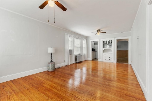 130 Francis St, Everett, MA 02149 - unfurnished living room with ceiling fan, radiator heating unit, light wood-style flooring, and ornamental molding