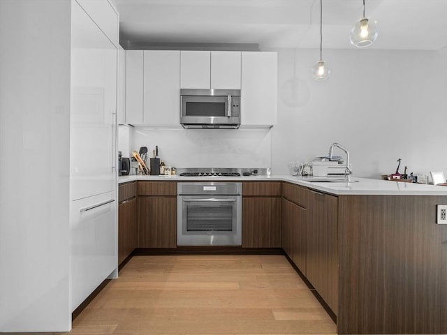 100 Shawmut Ave Unit 709, Boston, MA 02118 - kitchen featuring appliances with stainless steel finishes, white cabinetry, modern cabinets, light wood-style flooring, and light countertops