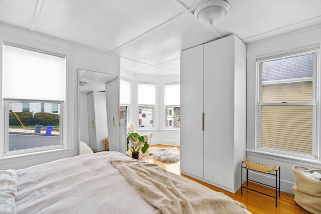 bedroom with wood finished floors and multiple windows