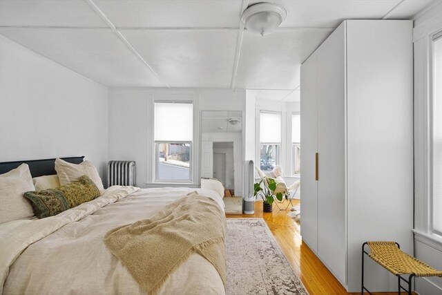 bedroom with multiple windows and radiator heating unit