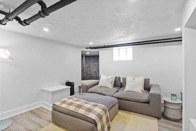 living area featuring baseboards, light wood-style flooring, and recessed lighting