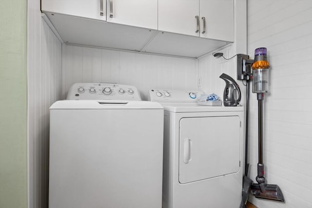 clothes washing area with washing machine and dryer and cabinet space