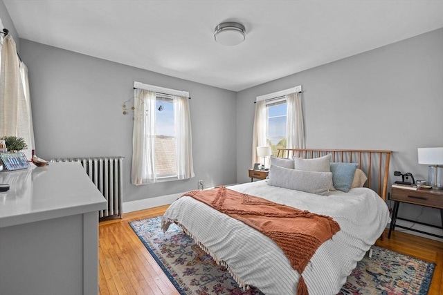 bedroom with light wood-style flooring and radiator heating unit