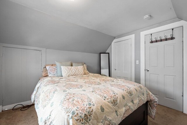 carpeted bedroom featuring lofted ceiling