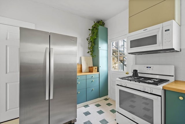 kitchen featuring light floors, decorative backsplash, butcher block countertops, and white appliances