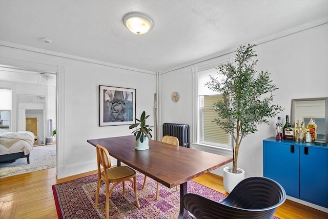 home office with radiator, light wood-style flooring, and baseboards