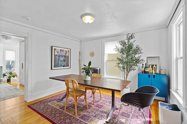 office area featuring light wood finished floors, ornamental molding, and a healthy amount of sunlight