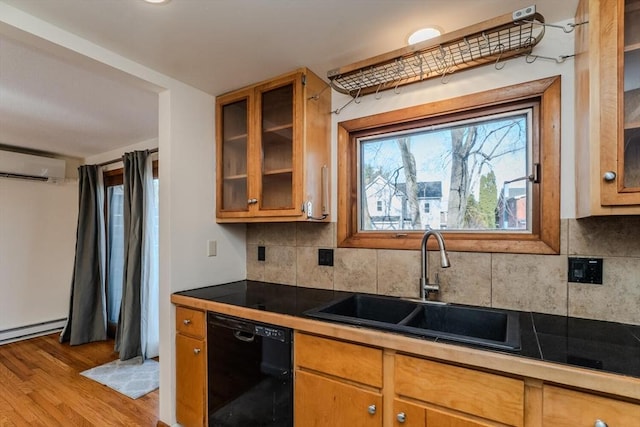 kitchen featuring light wood finished floors, backsplash, dishwasher, an AC wall unit, and a sink