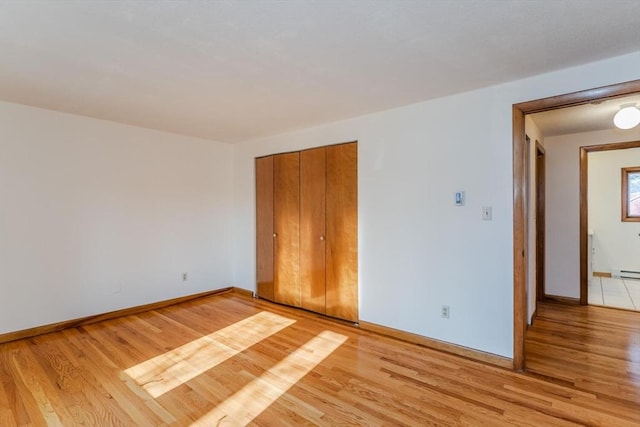 spare room featuring light wood-type flooring and baseboards