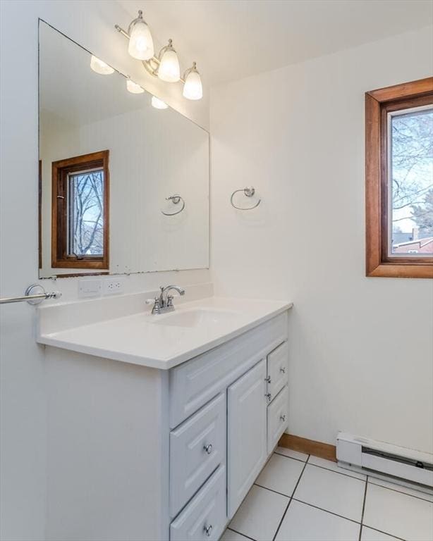 bathroom with a baseboard heating unit, tile patterned floors, vanity, and baseboards