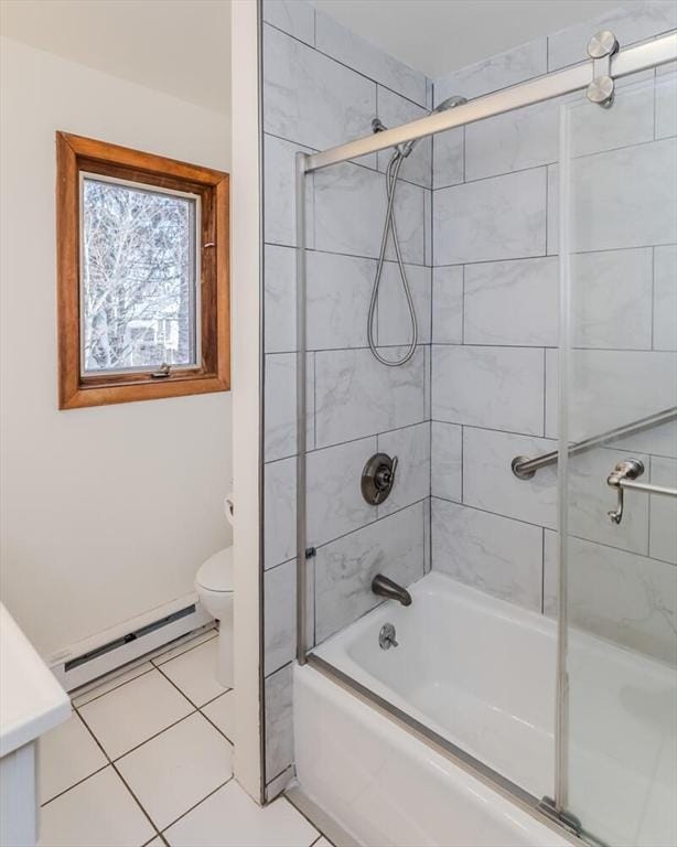 full bath with tile patterned floors, baseboard heating, shower / bath combination with glass door, and toilet