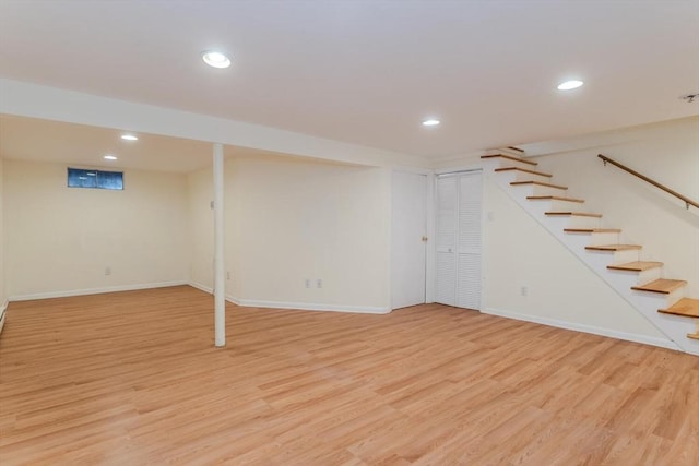 finished below grade area featuring stairway, recessed lighting, baseboards, and light wood-style floors