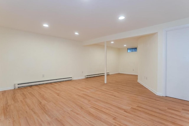 finished basement featuring recessed lighting, light wood-type flooring, and a baseboard radiator