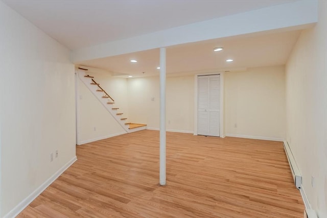 finished below grade area featuring stairway, light wood-style flooring, recessed lighting, and baseboards