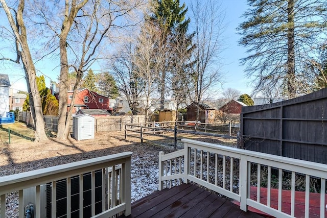 wooden deck with a residential view, an outbuilding, a storage shed, and a fenced backyard