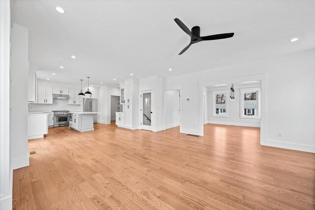 unfurnished living room featuring ceiling fan, recessed lighting, baseboards, light wood finished floors, and decorative columns