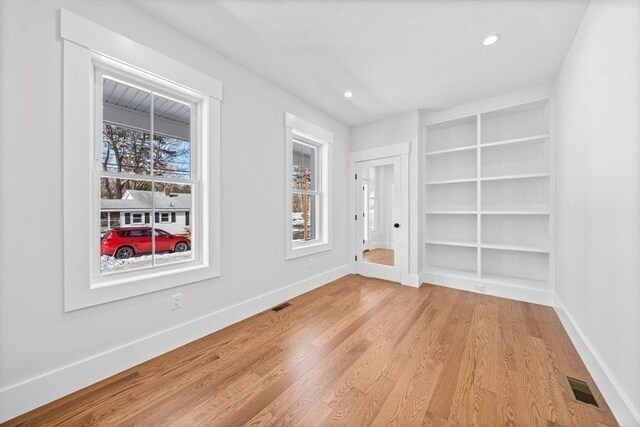 spare room with baseboards, visible vents, and light wood-style flooring