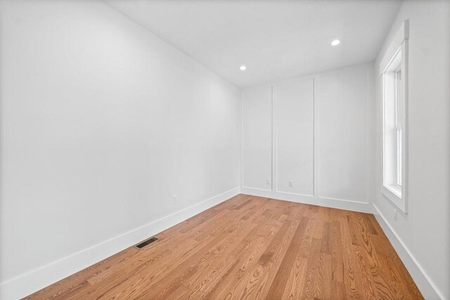 unfurnished room featuring recessed lighting, visible vents, light wood-style flooring, and baseboards