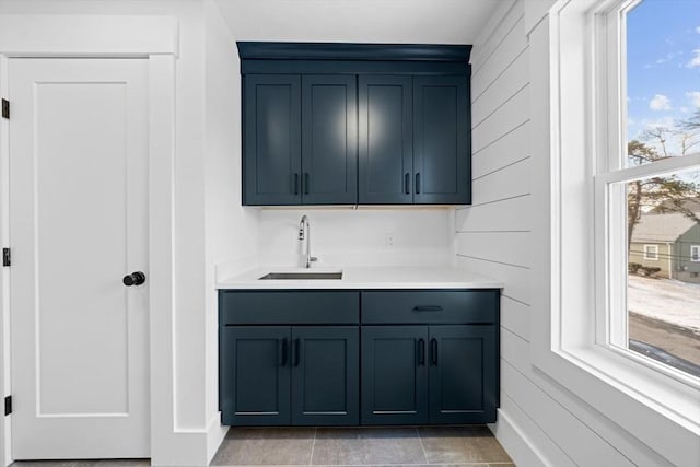 kitchen with blue cabinets, light countertops, and a sink