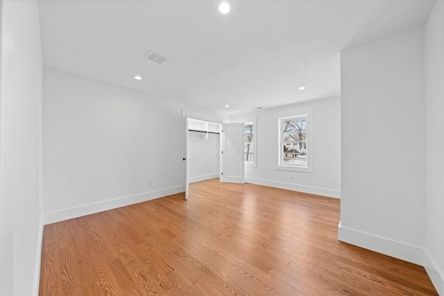 interior space with light wood-type flooring, visible vents, and baseboards