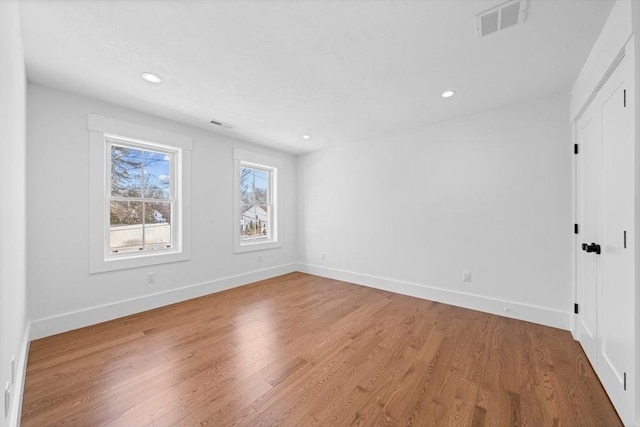 unfurnished room with light wood-style flooring, visible vents, baseboards, and recessed lighting