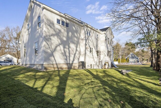 view of home's exterior featuring entry steps and a lawn