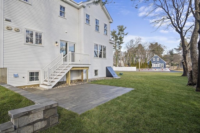 back of house with stairs, a yard, and a patio