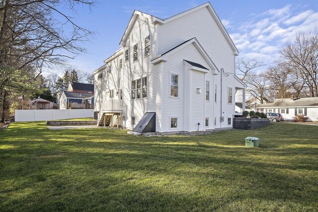 back of property featuring fence and a lawn