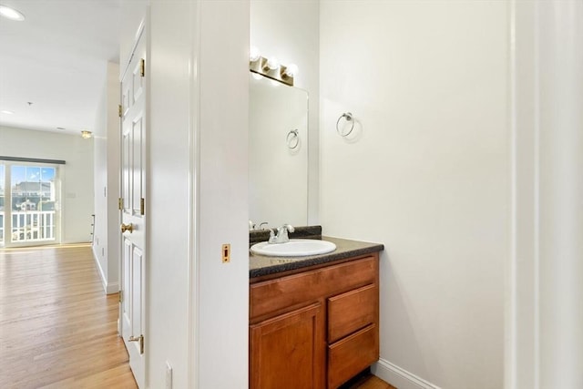 bathroom featuring vanity, baseboards, and wood finished floors