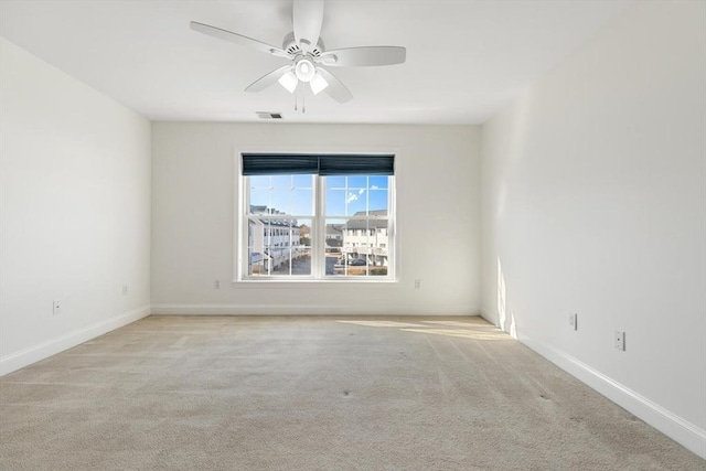 spare room with carpet, visible vents, ceiling fan, and baseboards