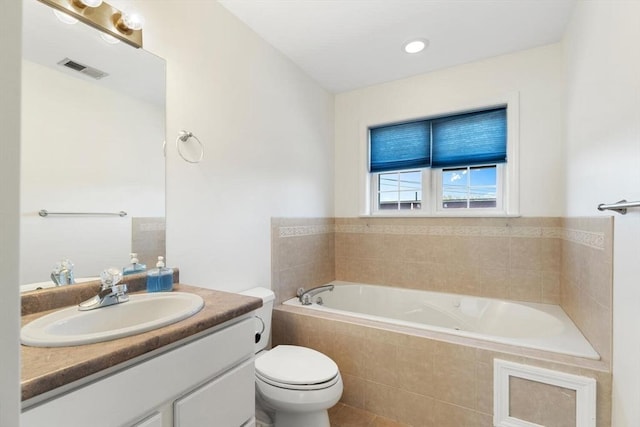 bathroom featuring visible vents, vanity, toilet, and a bath