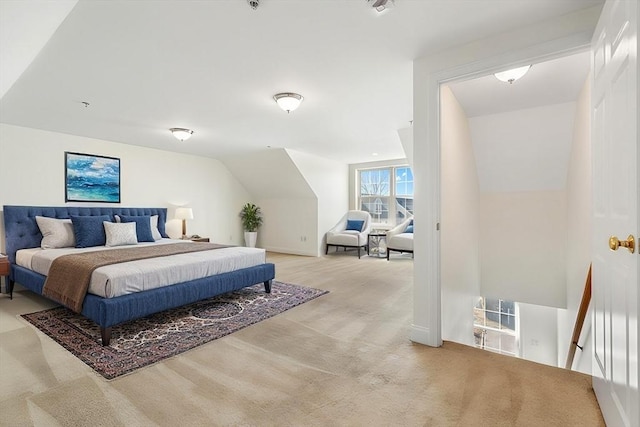 bedroom with lofted ceiling and light colored carpet