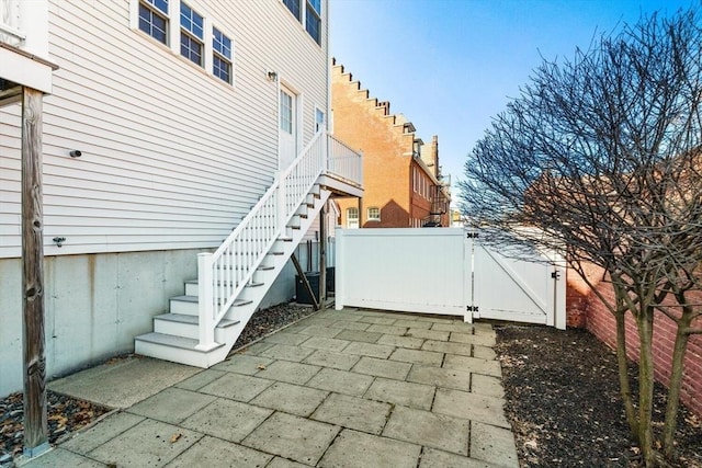 view of patio / terrace with stairway, a gate, and fence