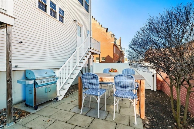 view of patio with stairs and fence