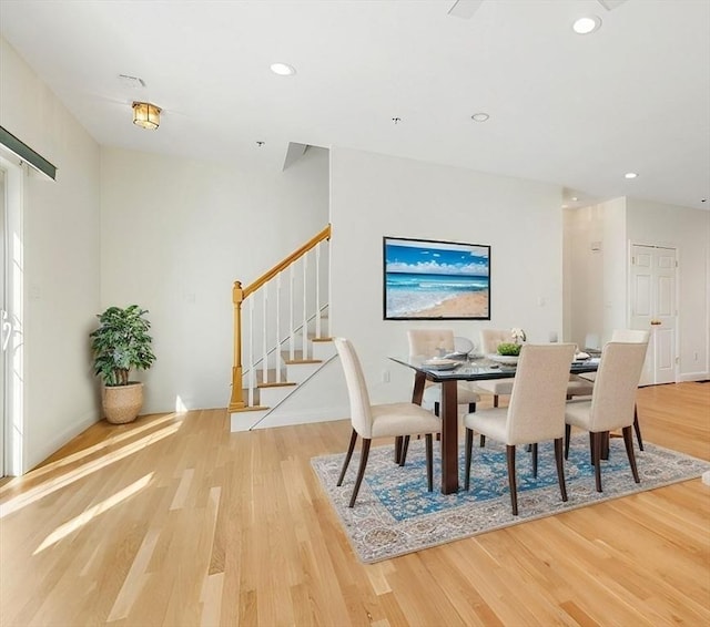 dining room featuring light wood-style floors, stairway, and recessed lighting