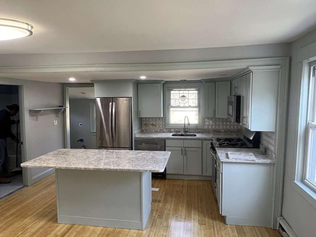 kitchen featuring stainless steel appliances, a sink, gray cabinetry, tasteful backsplash, and recessed lighting