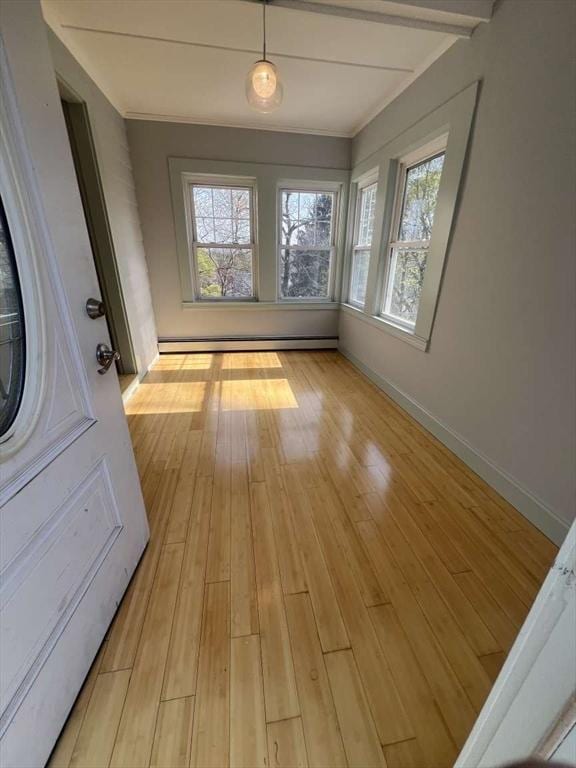 unfurnished dining area featuring light wood-style floors, beamed ceiling, baseboard heating, and baseboards