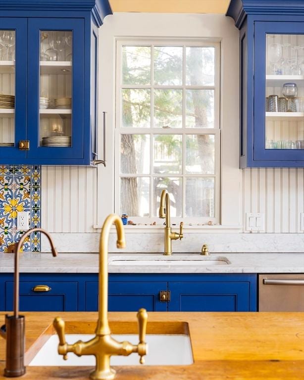 bar featuring backsplash, a sink, and dishwasher