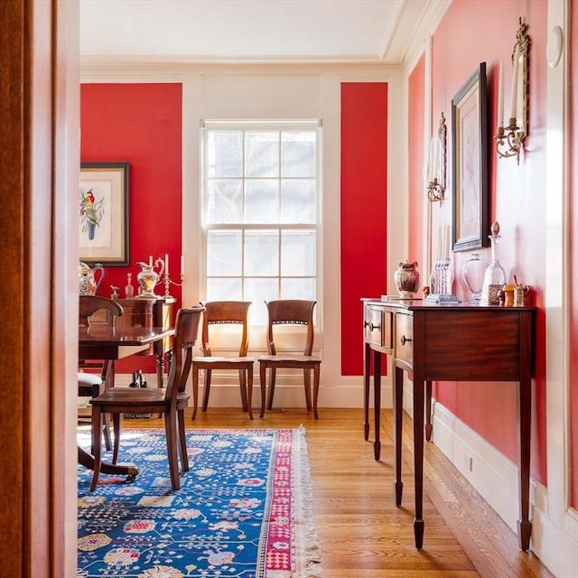 living area with crown molding, baseboards, and wood finished floors