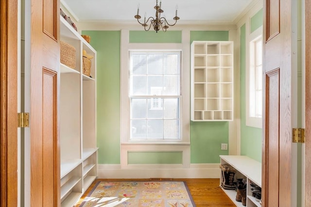 mudroom with crown molding, baseboards, wood finished floors, and a chandelier
