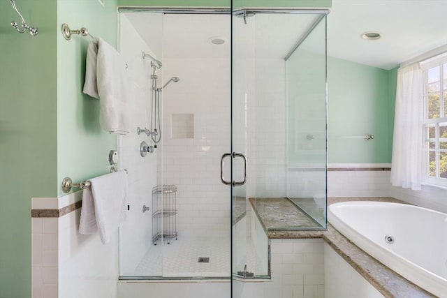 bathroom featuring a jetted tub and a stall shower