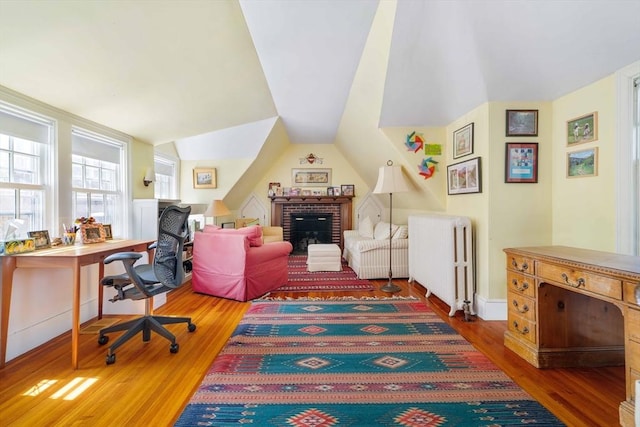 home office with wood finished floors and radiator heating unit