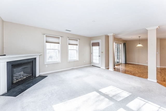 unfurnished living room with carpet and ornate columns