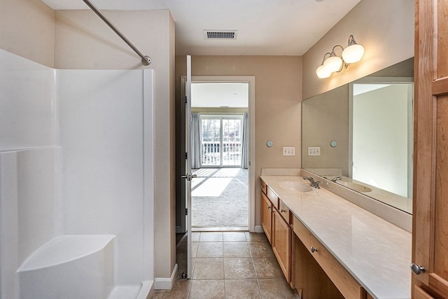 bathroom with a shower, vanity, and tile patterned flooring