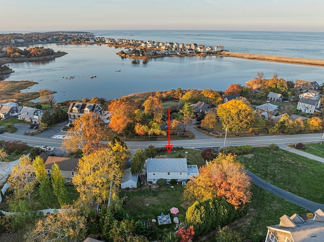 aerial view at dusk featuring a water view