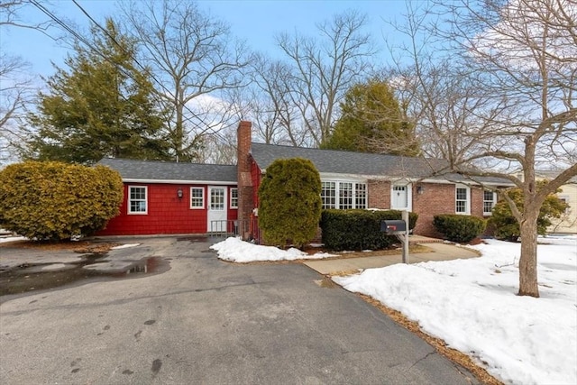 ranch-style house featuring aphalt driveway and a chimney