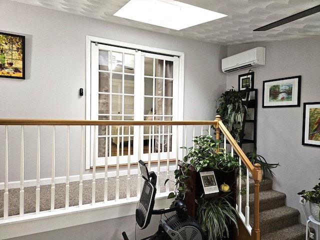 stairway featuring a skylight and an AC wall unit